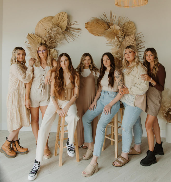 Seven stylists from The Natural, standing together in cream and denim outfits